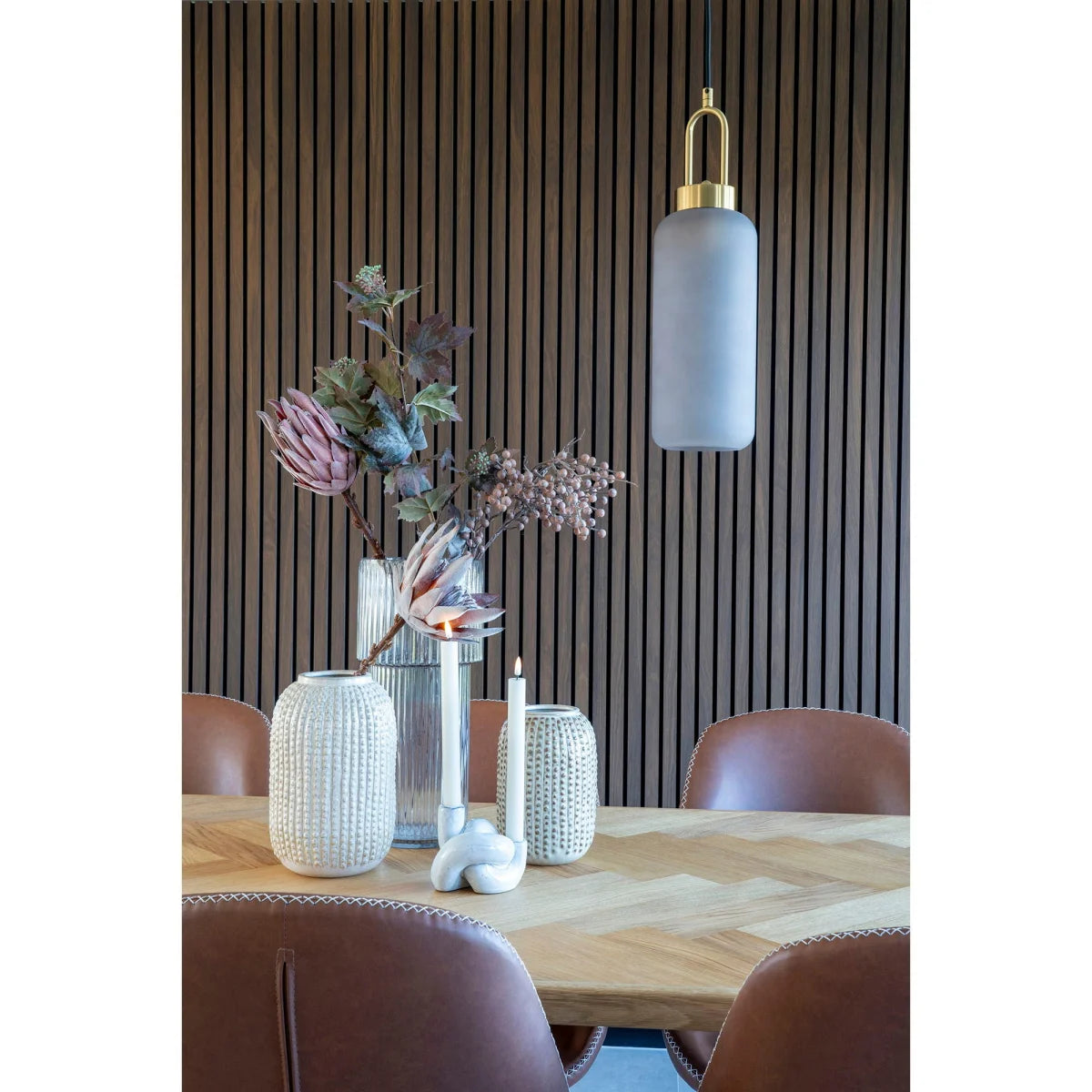 Lampe pendentif verre givré doré au-dessus table à manger