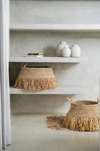 Panier en paille tissée avec frange shaggy, parfait pour la décoration intérieure