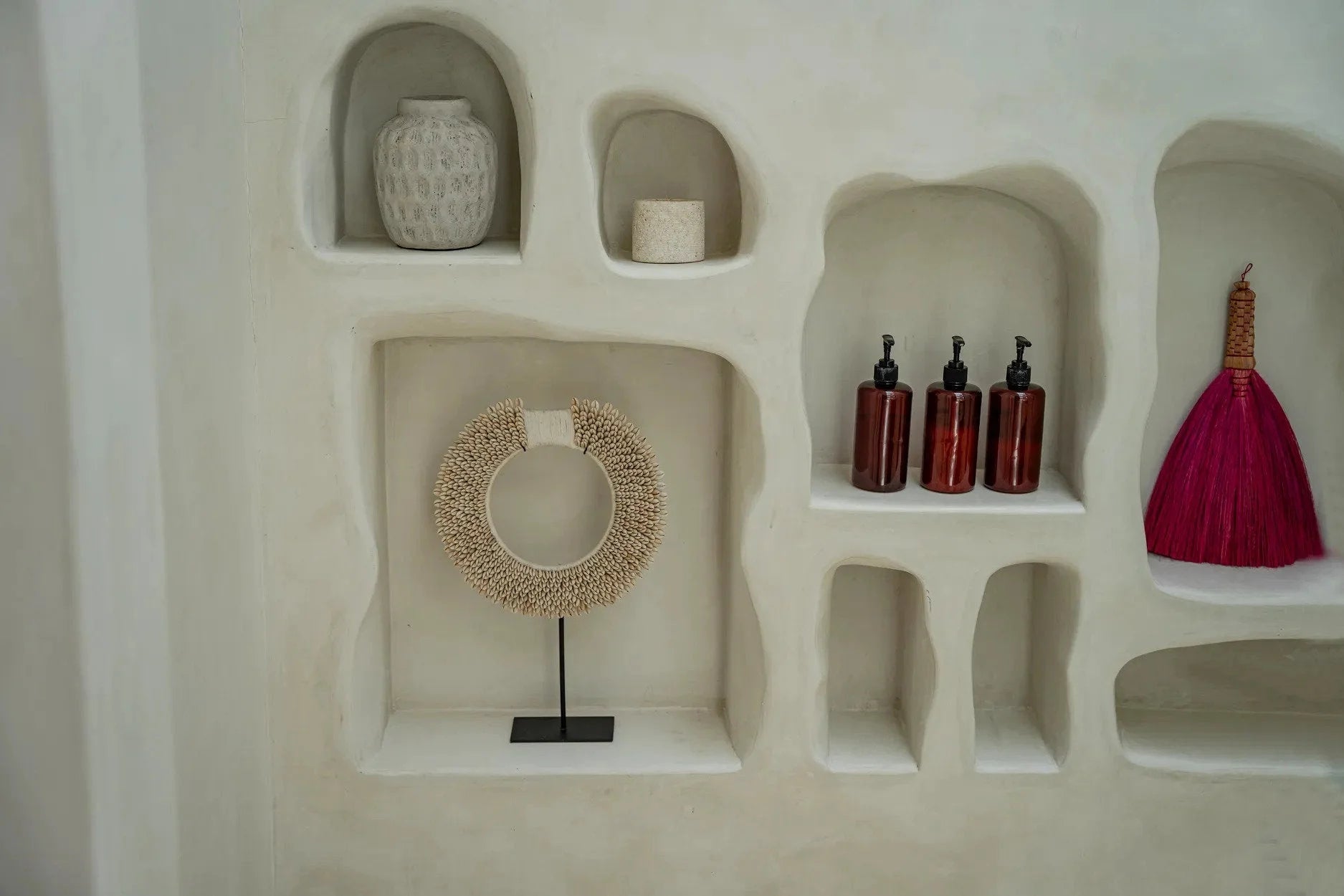 Vase rond en terre cuite gris effet béton avec étagères décoratives et objets variés